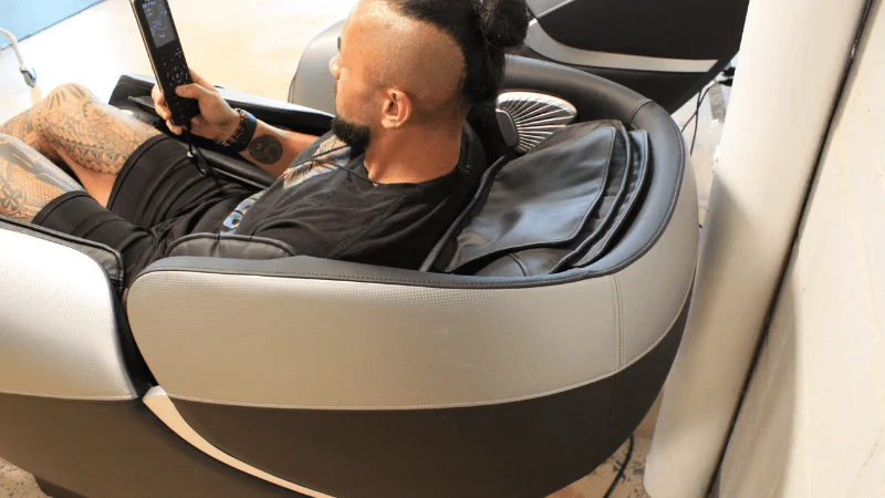 Our tester sitting in the Relaxe Zero-Gravity Shiatsu Massage Chair next to a wall