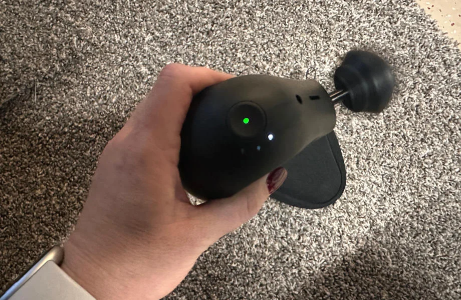 A person holding the Theragun Mini.