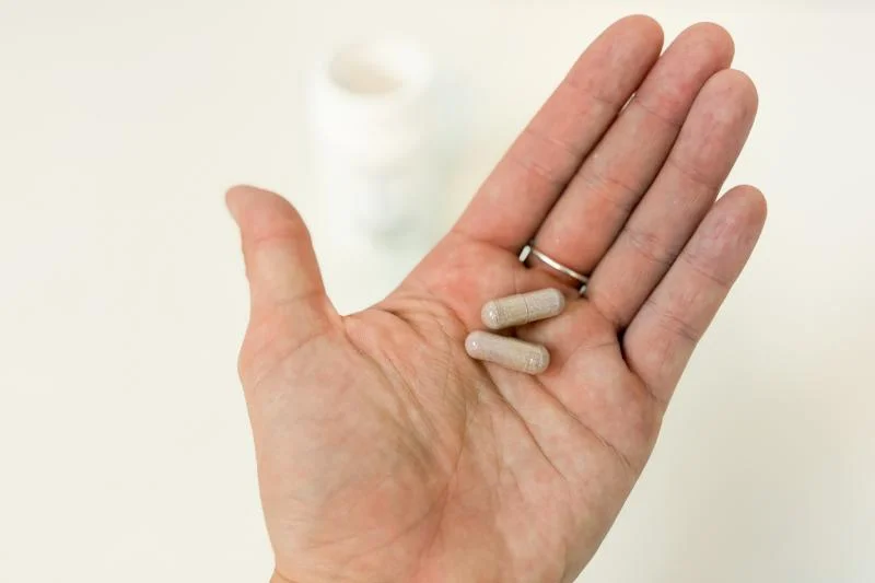 A product tester holding a couple of capsules of Pendulum Metabolic Daily