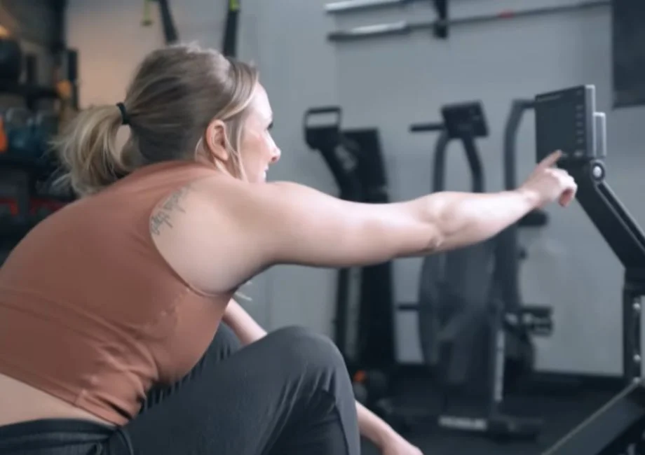 A woman using the PM5 monitor on a Concept2 RowErg
