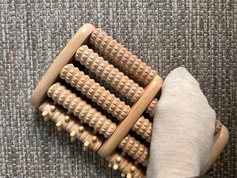 A close look at a Theraflow Foot Roller with somebody's foot on it.