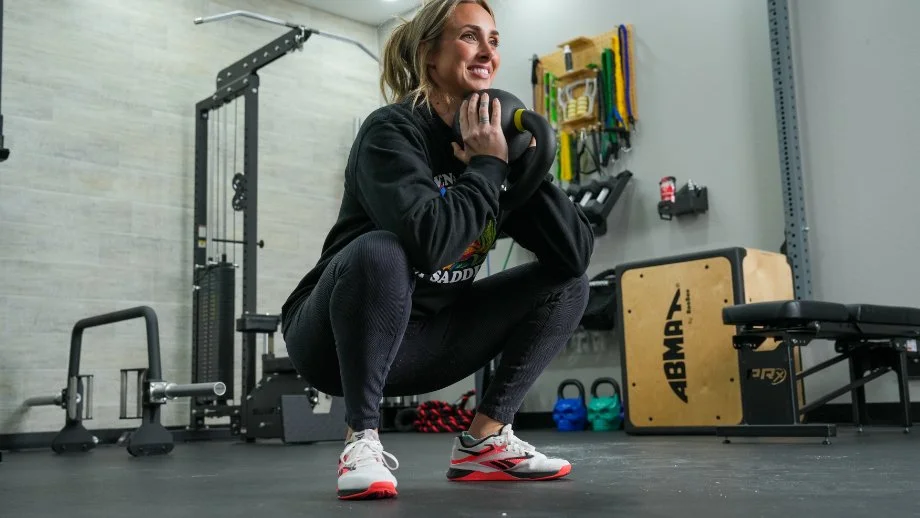 A person is shown doing squats wearing Reebok Nano X4 shoes.