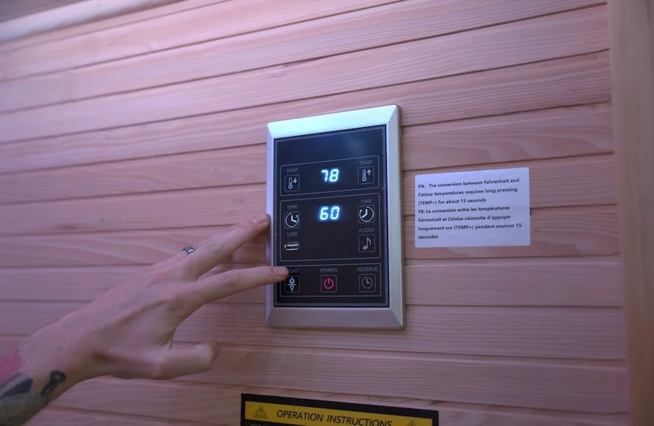 Our tester adjusting the temperate and time controls of the the Relaxe Caldera Infrared Sauna