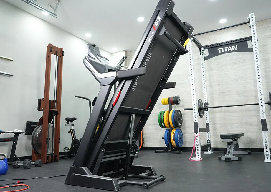 The Sole F63 Treadmill in a home gym, folded
