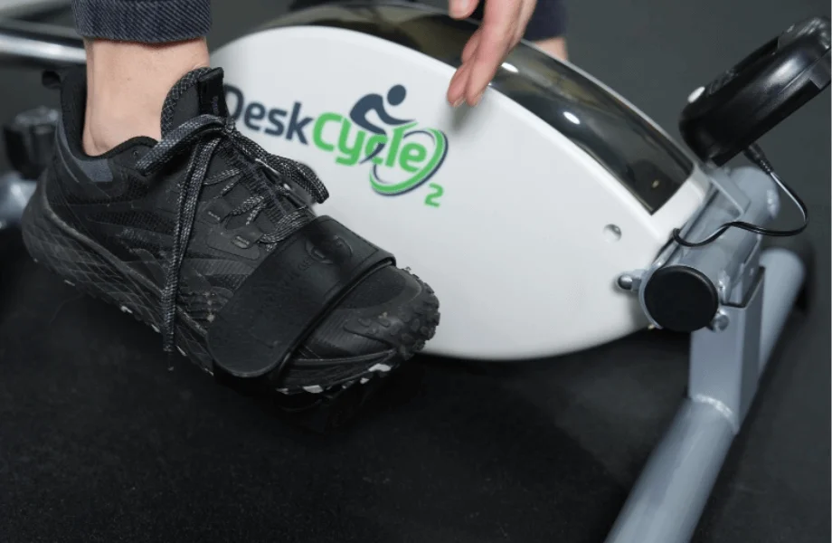 Our tester securing their feet into the DeskCycle 2 Under Desk Exercise Bike And Pedal Exerciser's pedal straps