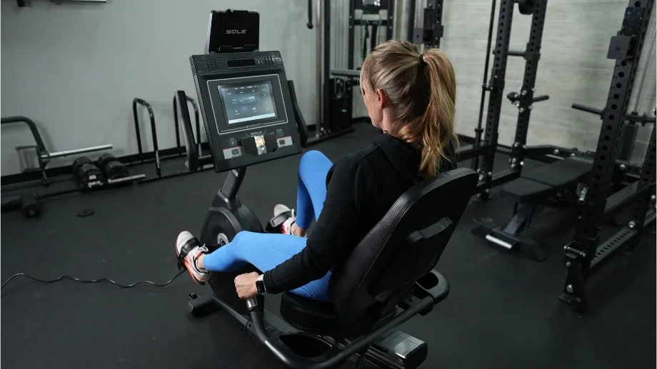 Looking over someone's shoulder at the screen on a Sole LCR Recumbent Bike.