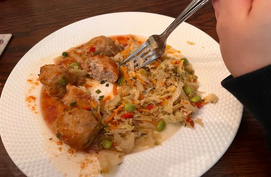 Our tester eating a BistroMD meal—Firecracker Chicken Meatballs with Asian Salad