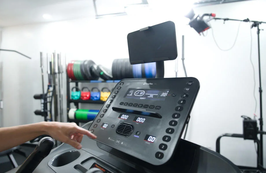 A person reaches for the controls an a BowFlex T6 Treadmill.