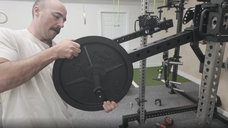 A person loading weight plates onto a pair of RVL Wings.