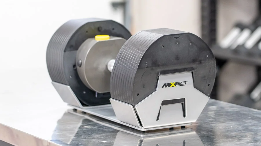 The dumbbells sitting on a metal counter.