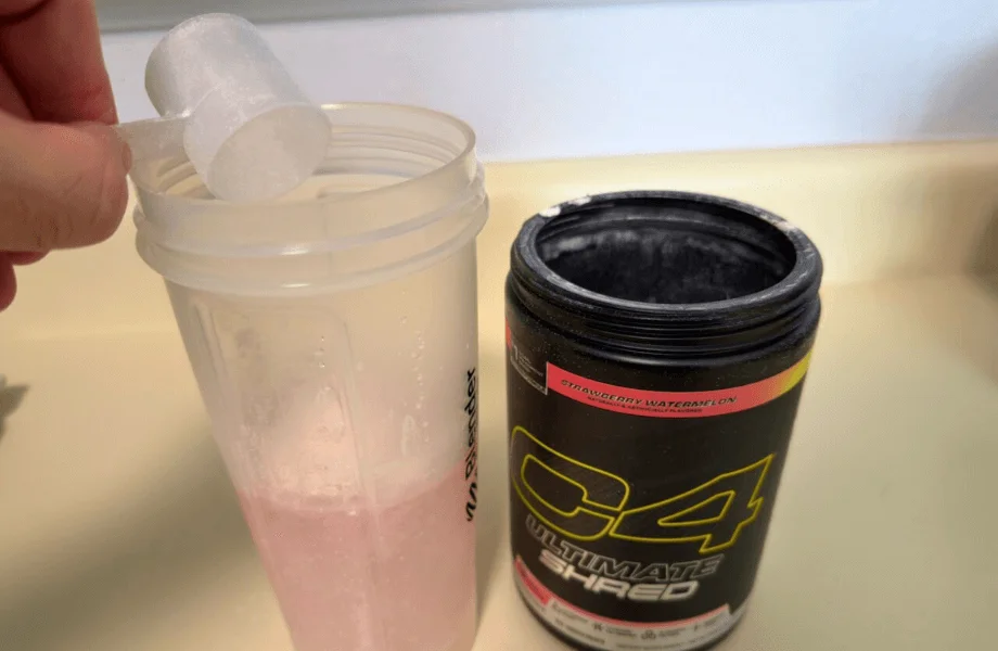 Our tester adding a scoop of Cellucor C4 Ultimate Shred pre-workout to their shaker bottle