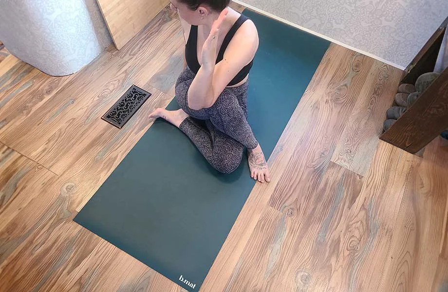 Woman doing yoga on a b, halfmoon b, mat yoga mat