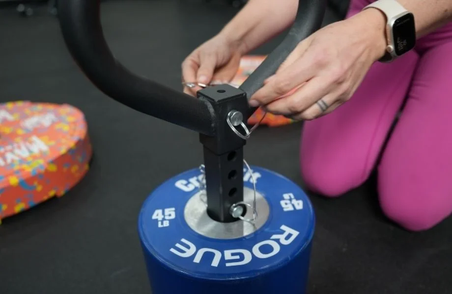 A GGR product tester adjusting the pin on the Titan Fitness Plate Loadable Kettlebell Swing