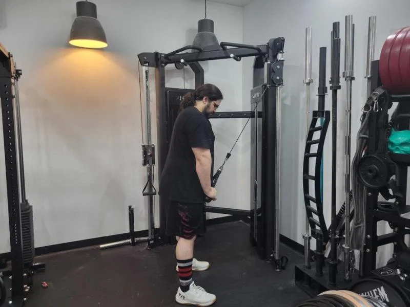 Our tester, Caine Wilkes, CPT, USAW-L1, CNC, doing triceps push-downs on the XMark Functional Trainer.
