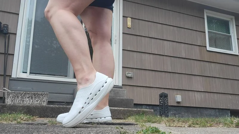 A person posing with a pair of Stand+ AntiGrav 1 recovery shoes.