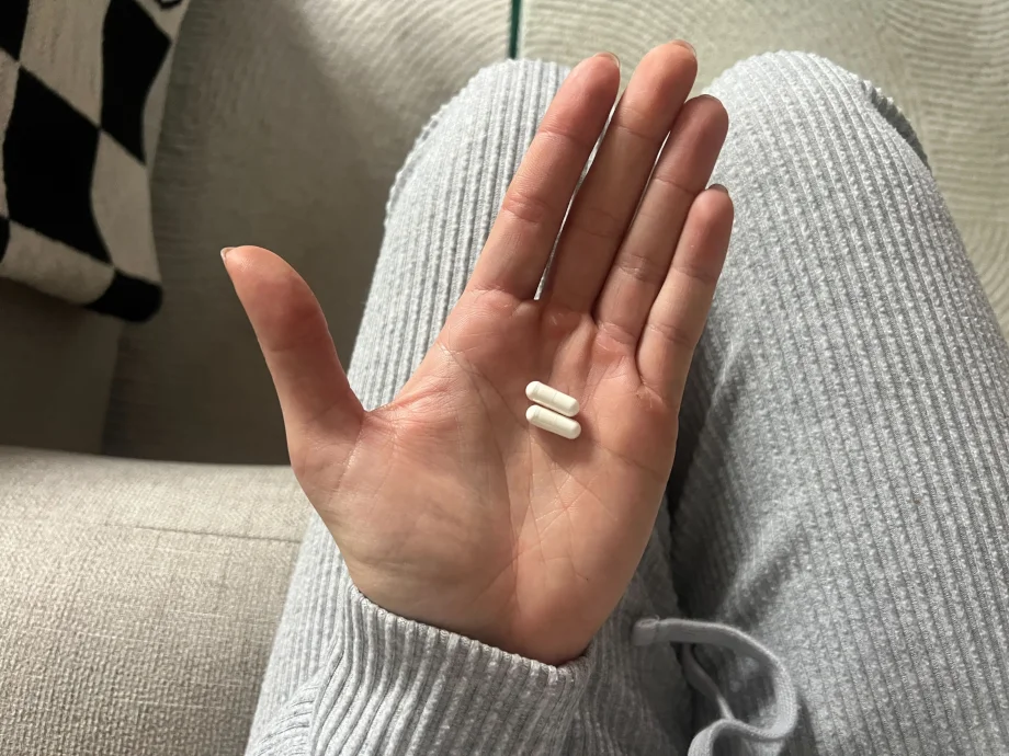 A person holding some Pure Encapsulations Melatonin capsules.