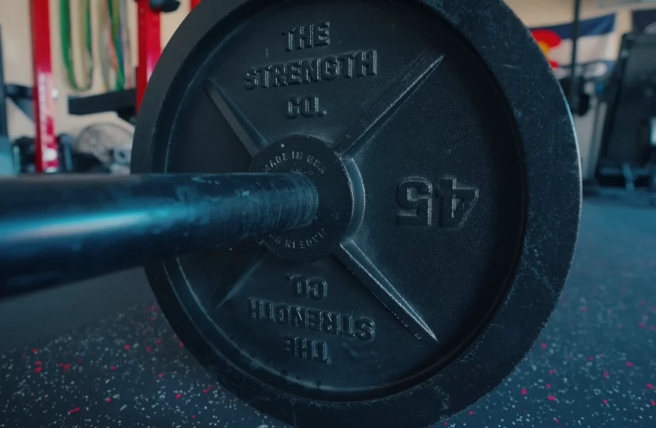 A 45-pound The Strength Co. Olympic Iron Barbell Plate loaded onto a bar