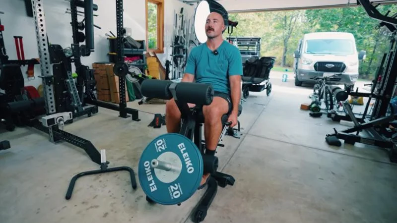 Coop performing leg extensions on the Freak Athlete ABX Weight Bench
