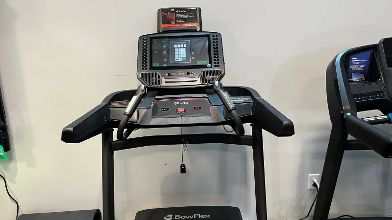 View of the Bowflex T6 treadmill including the display screen, media shelf, handles, and heart rate monitor