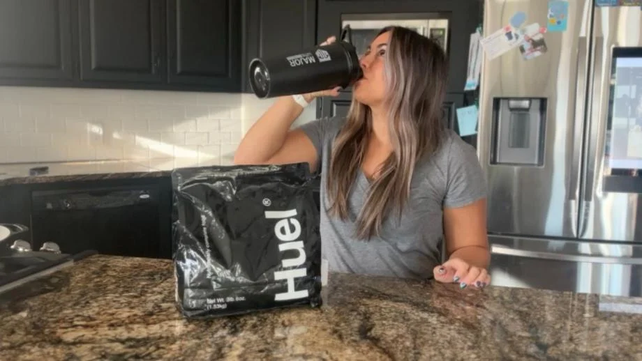 Woman drinking Huel Black Edition
