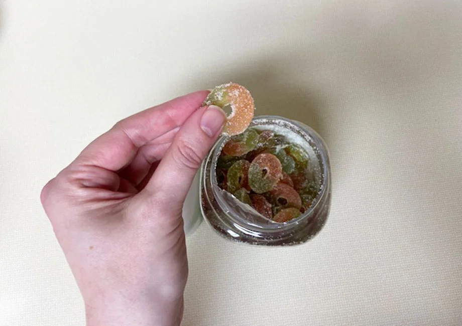 A hand holds some Olly Fiber Gummies.