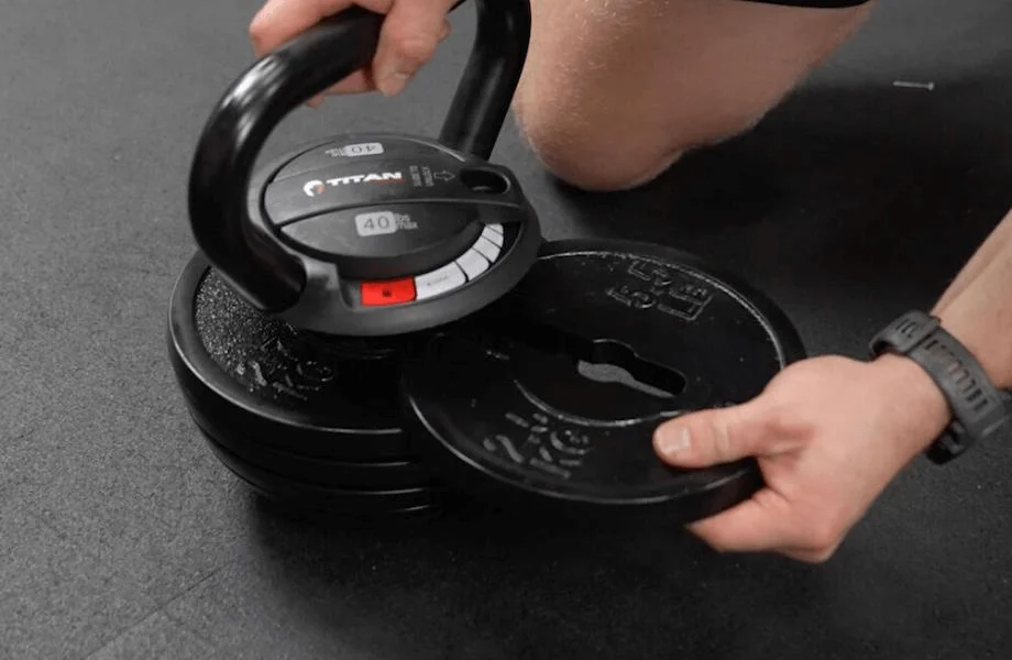 Athlete removing a weight plate from the Titan Fitness Adjustable Kettlebell