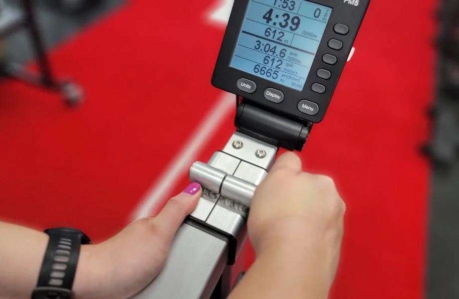 Person adjusting the monitor and handlebar on the Concept2 BikeErg