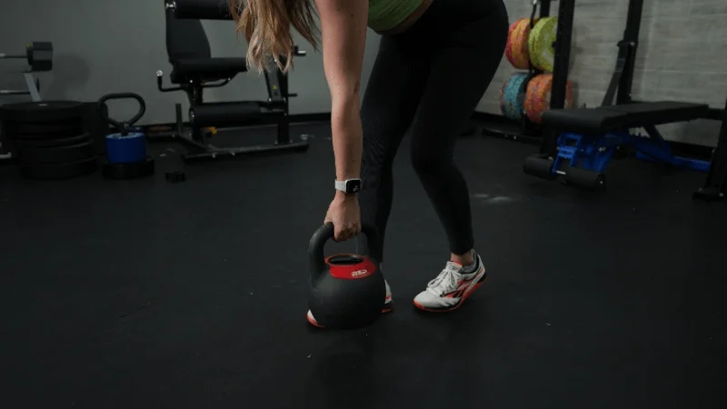Our tester picking up the REP Fitness Adjustable Kettlebell in the GGR testing center