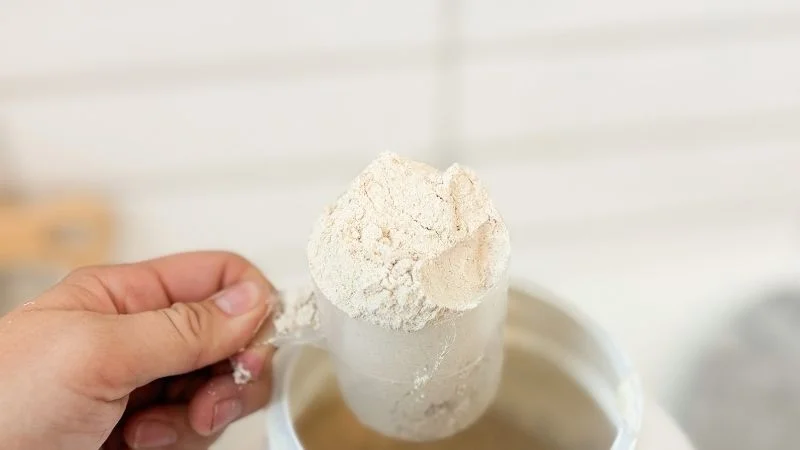 A close up view of a full scoop serving of Nutricost Meal Replacement Shake powder in our tester's hand.