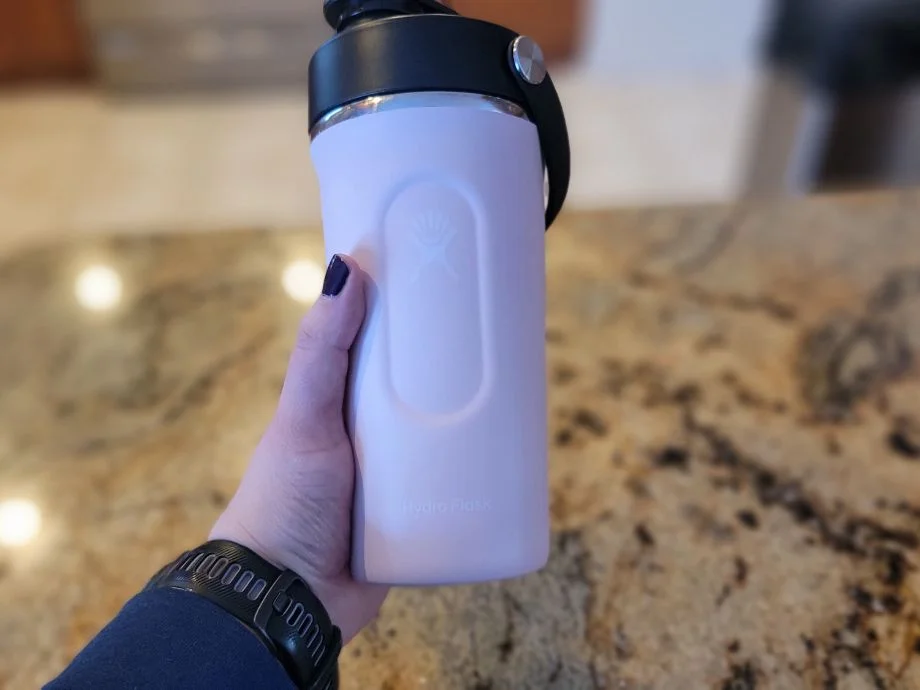 A person holding the Hydro Flask Shaker Bottle after mixing up a protein shake