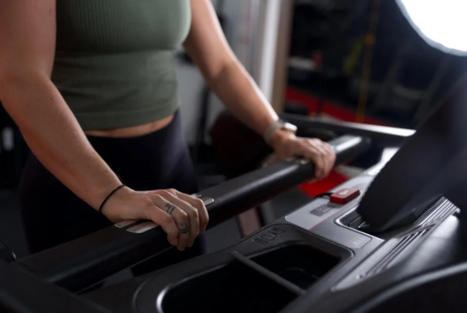 woman holding onto sole fitness tt8 treadmill handles