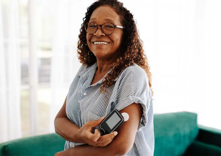Woman using a continuous glucose monitor to check her blood sugar levels