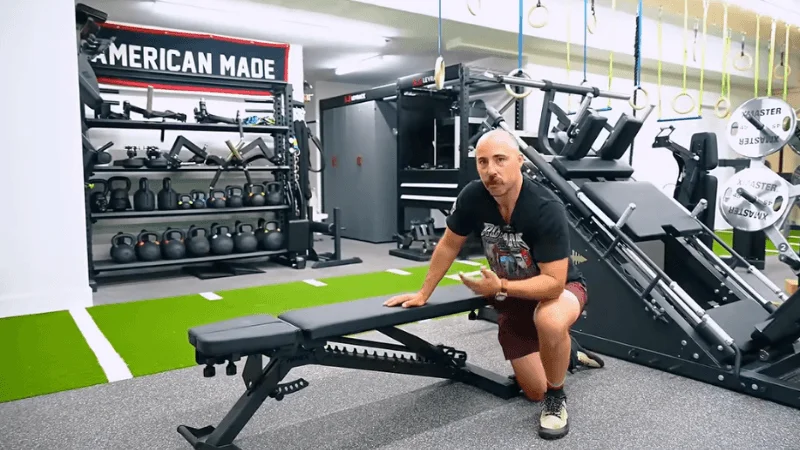 Our tester examining the Tib Bar Guy Apex Adjustable Bench in their home gym