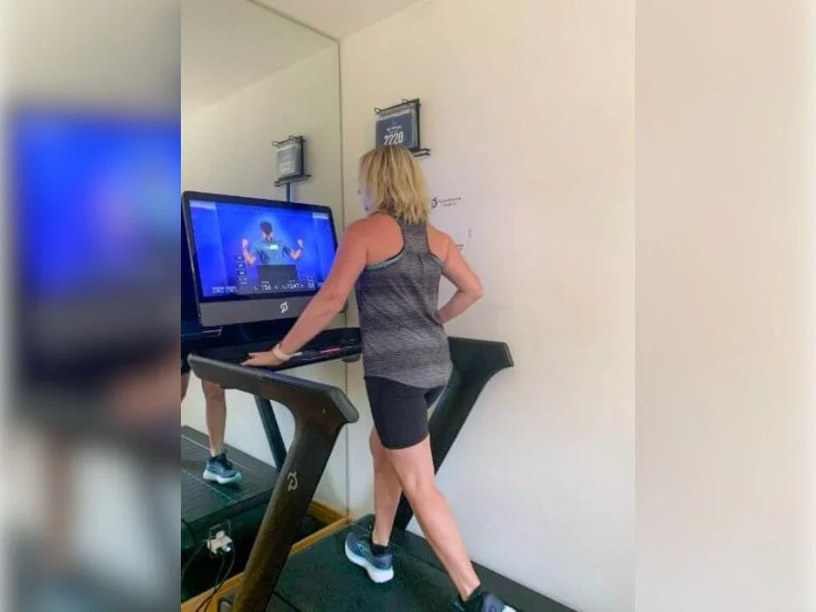 A woman walking while using the Peloton Tread