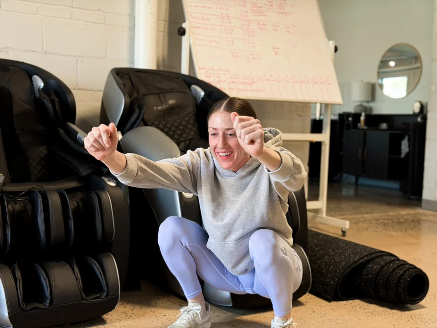 A woman doing squats while using the Muscle Booster app