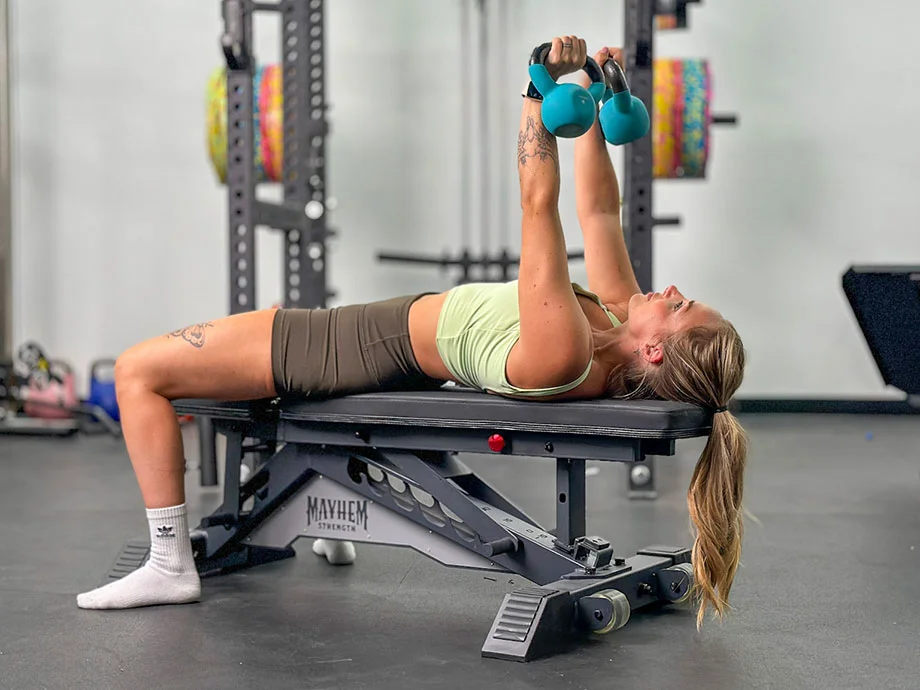 person-performing-kettlebell-bench-press