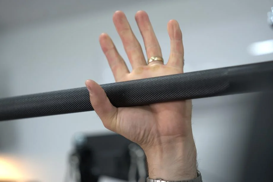 Man about to grip the pull-up bar of the Body-Solid Functional Trainer Rack