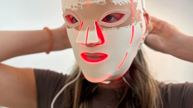 putting-on-the-renpho-led-light-therapy-mask-3 A person putting on the Renpho LED Light Therapy Mask.
