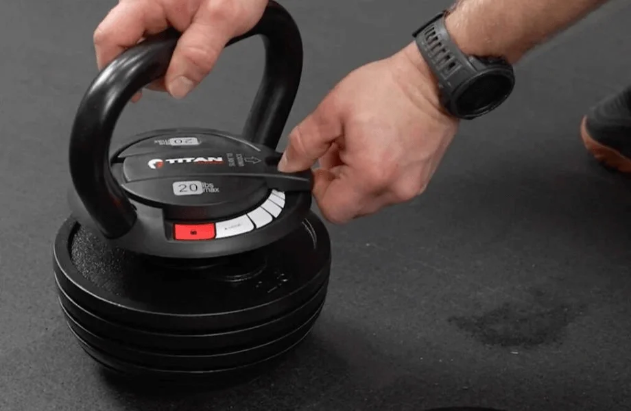 Athlete engaging the locking mechanism on the Titan Fitness Adjustable Kettlebell