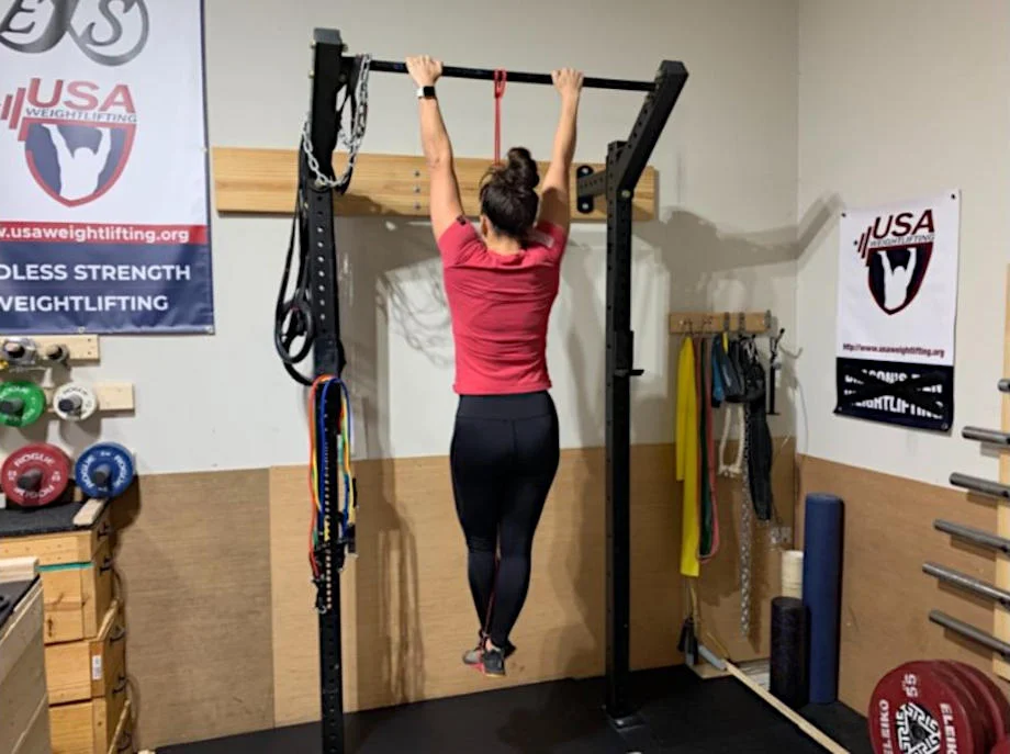 Woman hanging on pull-up bar