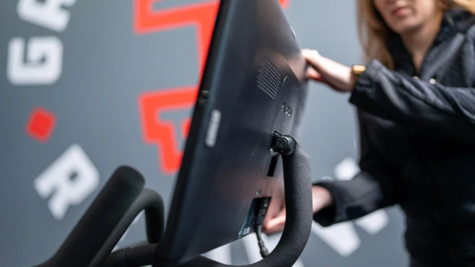A GGR product tester tilting the screen on the Peloton bike