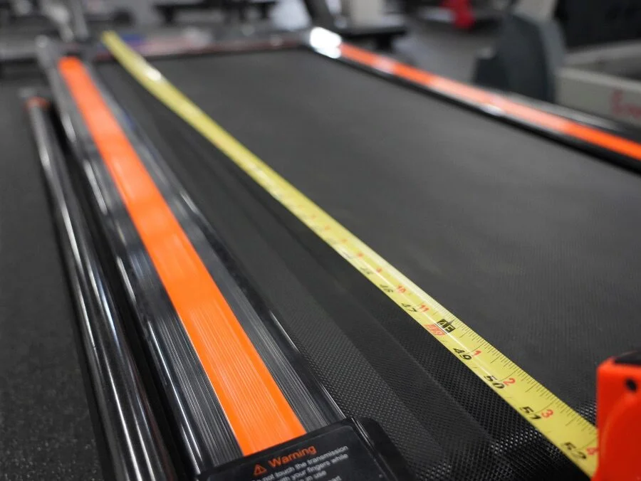 Showing how short the UREVO treadmill deck is with a measuring tape