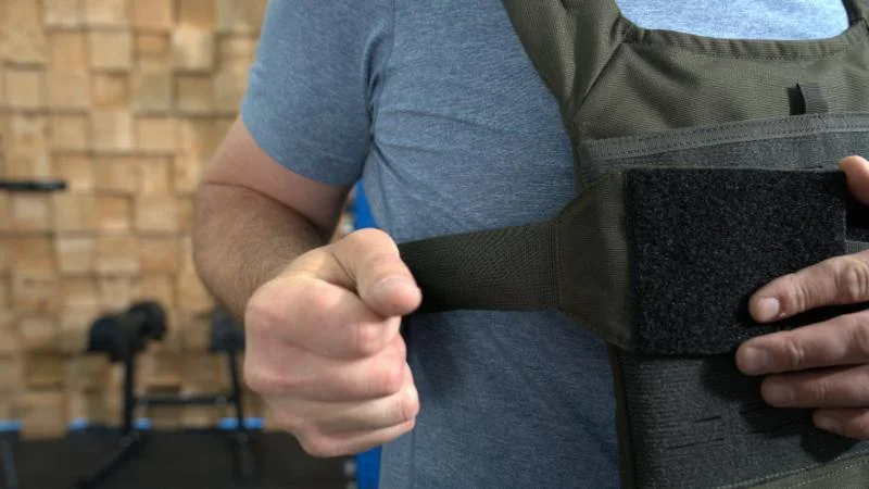 A tester secures the REP Fitness Strata Weight Vest before his workout