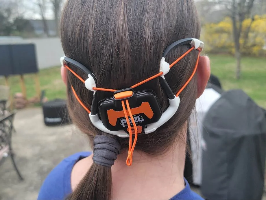 Close rear view of a woman wearing a PETZL Iko Core headlamp