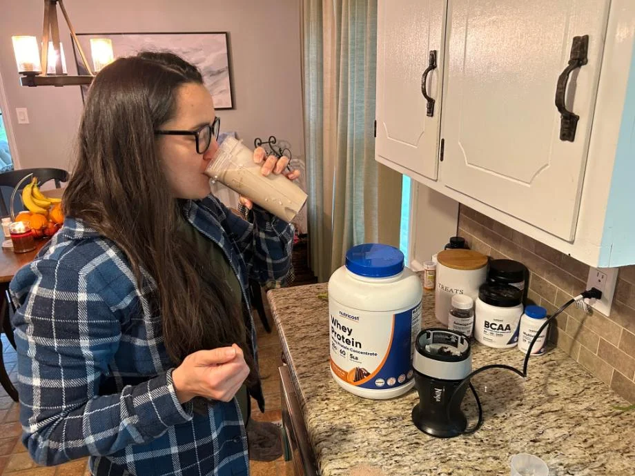 A woman drinking a Nutricost Whey Protein shake
