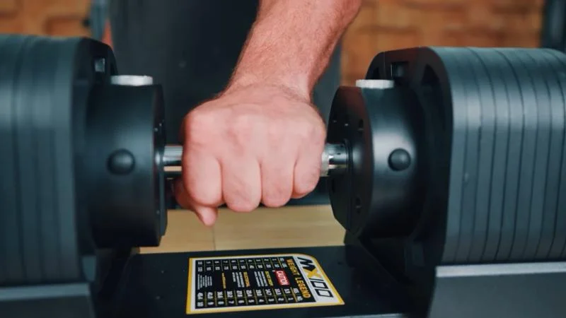 A man's hand gripping onto the MX100 Evo Series Dumbbells