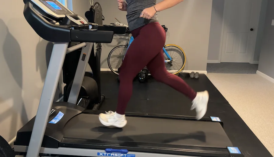 An image of a woman running in the Quince high-rise utility running tight