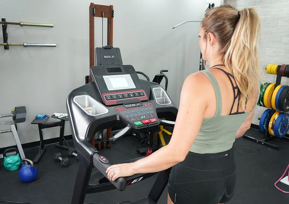 Woman on the Sole F63 Treadmill looking at the display screen