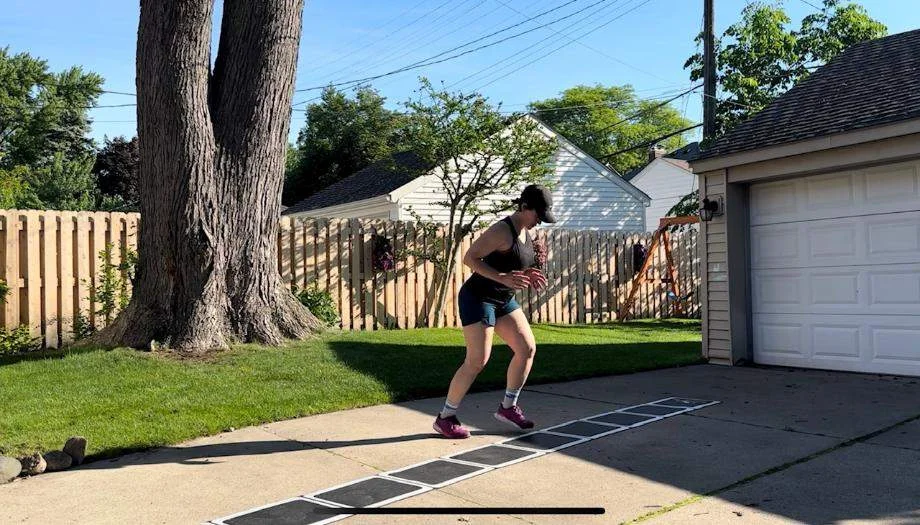 A woman does footwork drills with the Stroops Roll Out Agility Ladder.