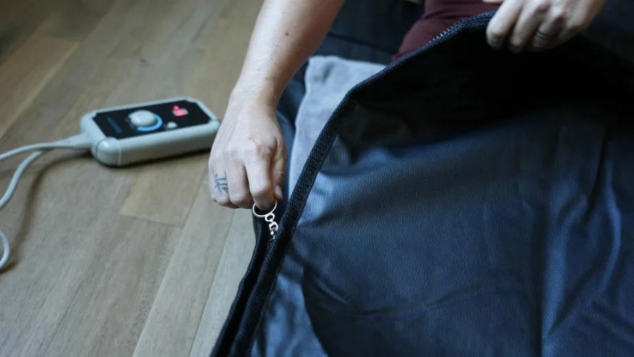 HigherDose woman zipping sauna blanket